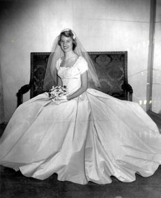 an old black and white photo of a woman in a wedding dress