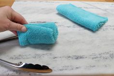 someone is cleaning the marble counter top with blue towels