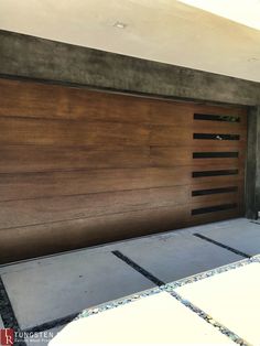 a garage door is shown in front of a house with concrete and wood sidings