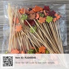 some sticks with fall leaves on them are in a plastic bag and it is sitting on top of a wooden table