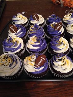 cupcakes with purple frosting and football decorations