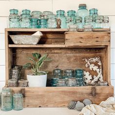 an old wooden shelf filled with jars and other items