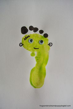 a drawing of a green creature with black dots on it's head and eyes