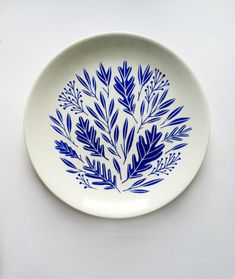 a blue and white plate with leaves on it