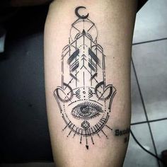 a black and white hamsa tattoo on the arm