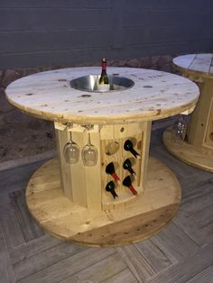 an outdoor table made out of wooden pallets with wine bottles on top and two chairs around it