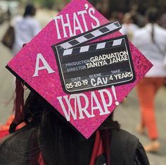 a woman wearing a pink graduation cap with the words that's a wrap on it