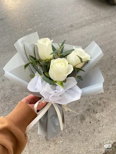 a person holding a bouquet of white roses