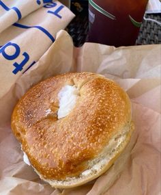 a close up of a bagel on a table near a cup and napkins