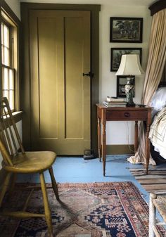 a bedroom with a bed, chair and pictures on the wall