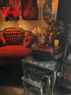 a living room with red couches and candles on the table in front of it