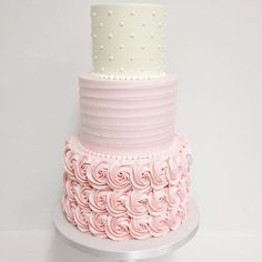 a three tiered cake with pink frosting roses