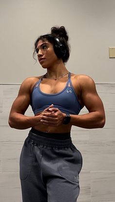 a woman standing in front of a mirror with her hands on her hips and looking at the camera