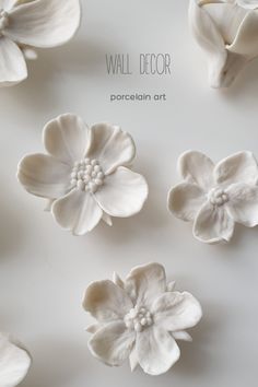 some white flowers are on a table with the words wall decor written above them and below it