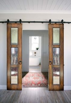 an open door leading to a bathroom with a rug on the floor