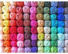 multicolored skeins of yarn are arranged in a rainbow - hued pattern