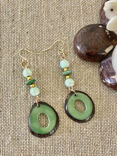 Handmade in Ecuador Earrings Length: 2.5 Inches Material: Tagua Nut Due to this item being handmade and the nature of the Tagua Nut the size and the color may vary from piece to piece Brown Round Bead Earrings For The Beach, Handmade Teardrop Earthy Earrings, Handmade Earthy Teardrop Earrings, Green Artisan Round Bead Earrings, Handmade Green Bohemian Plug Earrings, Green Artisan Dangle Earrings, Green Bohemian Hoop Earrings Hypoallergenic, Bohemian Green Hoop Earrings Hypoallergenic, Handmade Nature-inspired Drop Earrings