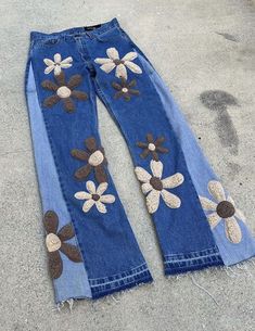 an old pair of jeans with flowers painted on the side and holes in the back