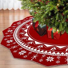 a christmas tree with presents under it on a red rug in front of a christmas tree