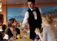 a waiter serving food to people at a restaurant