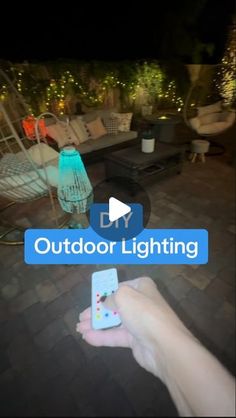 someone is holding their cell phone and pointing to the screen that shows an outdoor lighting