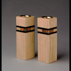 two wooden salt and pepper shakers with black bands on each side, one in the shape of a rectangle