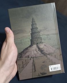 a person holding up a book with a drawing on it's front cover,