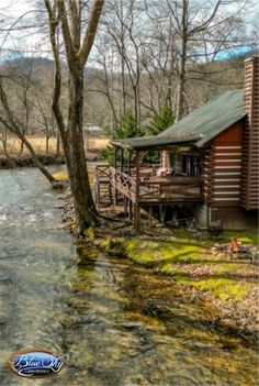 a log cabin sits next to a river