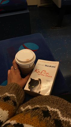 a person is reading a book and drinking coffee