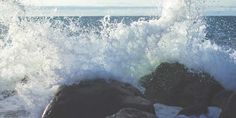 an ocean wave hitting on rocks in the water