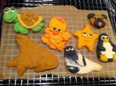 there are some cookies that look like animals and sea creatures on the cookie sheet together