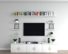 a flat screen tv mounted to the side of a wall next to bookshelves