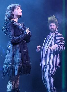 two people dressed in costumes on stage