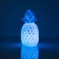 a lit up blue pineapple sitting on top of a table