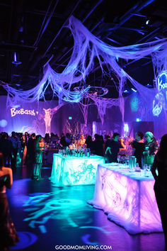 A vibrant party scene featuring colorful lighting and spooky decorations, including spider webs, with guests socializing around illuminated tables. Halloween Birthday Decoration Ideas, 60th Birthday Halloween Theme, Prom Night Halloween Party, Spooky Halloween Birthday Party, Huge Halloween Party, 16th Halloween Birthday Party, Spooky Party Decor, Middle School Halloween Dance Decorations, Halloween Dance Party Decorations