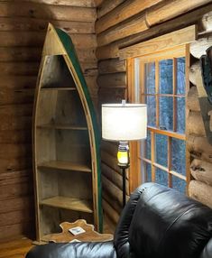 a living room filled with furniture next to a wooden wall mounted book shelf and window