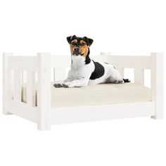 a small dog laying on top of a white bed with no headboard and legs