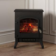 a wood burning stove in a room with white walls and wooden flooring on the side