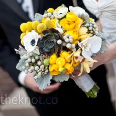 the bride and groom are holding their bouquets in their hands, both wearing black tuxedos