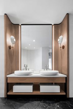 a bathroom with two sinks and mirrors on the wall next to each other in front of a large mirror