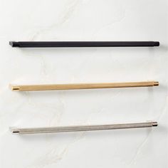 three different types of chopsticks on a white surface with black and gold handles