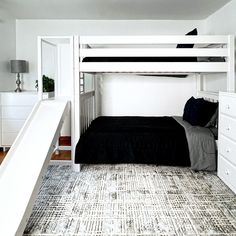 a white bunk bed sitting in a bedroom next to a dresser and stairs leading up to it