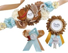 three ribbons with flowers and cowboy hats on them, one for the baby to be