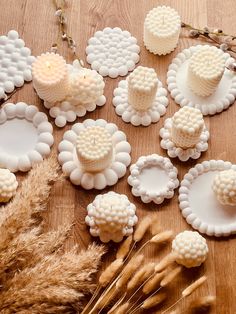 there are many small white objects on the wooden table next to some dried grass and wheat stalks