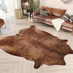 a living room with two couches and a cowhide rug on the floor in front of it