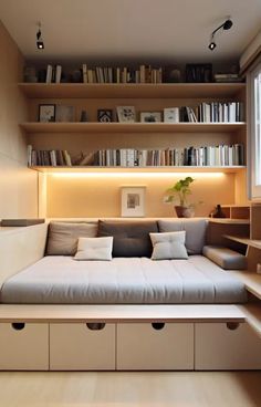 a living room filled with lots of furniture and bookshelves next to a window