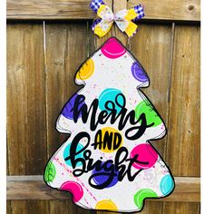 a merry and bright christmas tree door hanger on a wooden fence with a bow