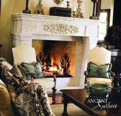 a living room filled with furniture and a fire place in the middle of a fireplace