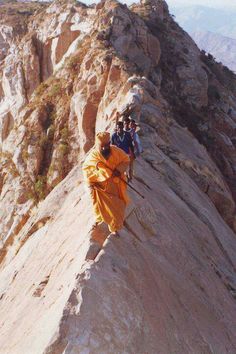 a group of people climbing up the side of a mountain