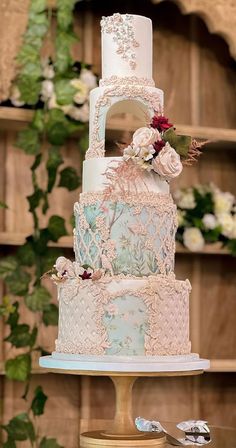 a three tiered wedding cake sitting on top of a table